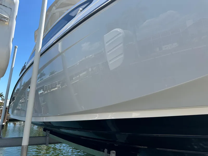 Slide: The Image of 2023 Yamaha Boats 275 SDX in marina, reflecting water and surroundings. - 10