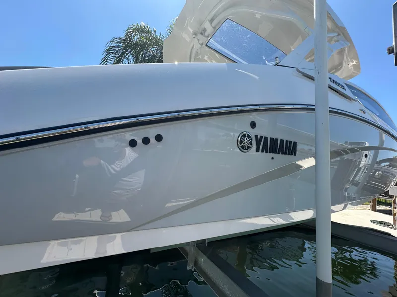 Slide: The Image of 2023 Yamaha Boats 275 SDX in white, docked under clear blue sky. - 11