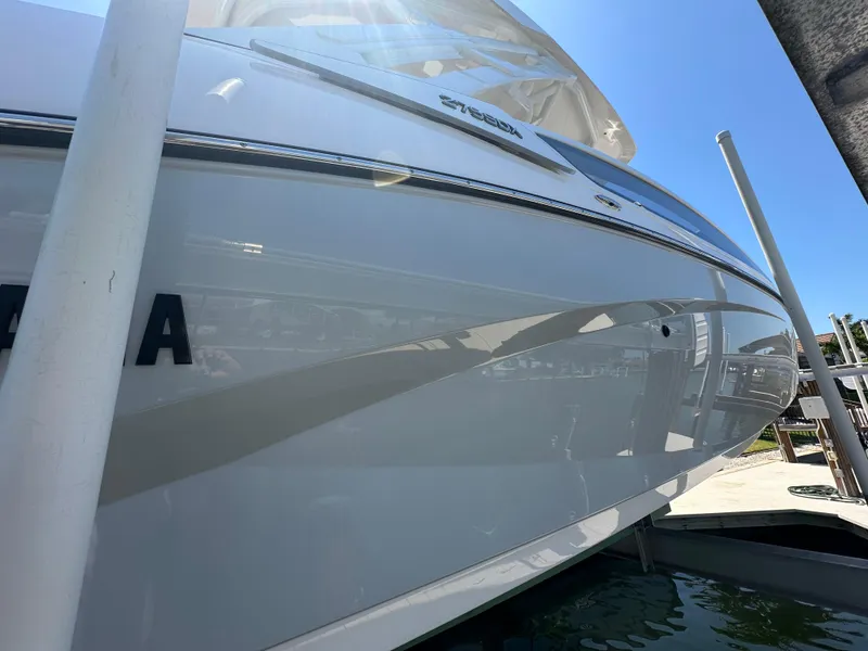 Slide: The Image of 2023 Yamaha Boats 275 SDX, sleek design, docked under bright blue sky. - 12