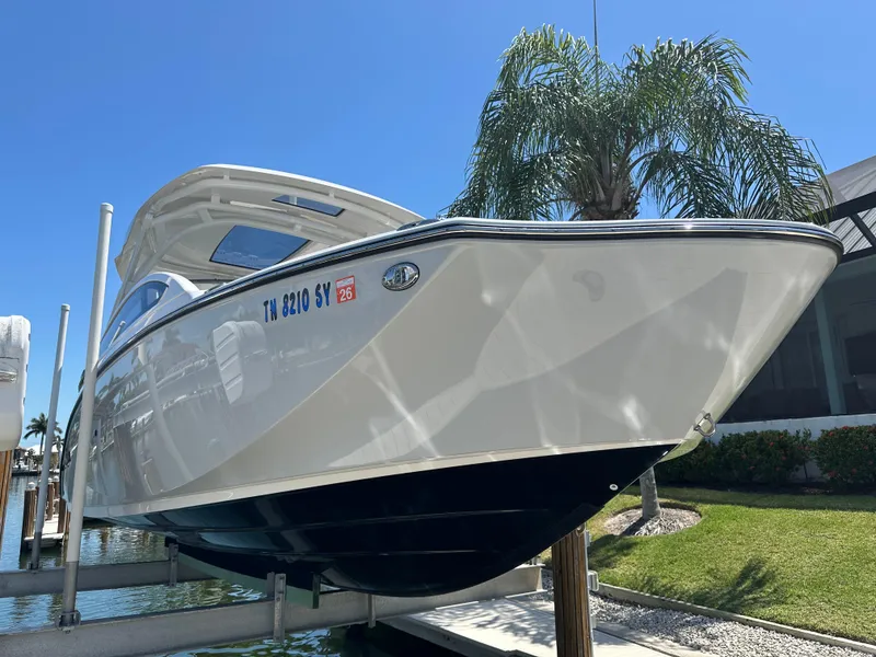 Slide: The Image of 2023 Yamaha Boats 275 SDX on lift, sunny day, palm tree background. - 9