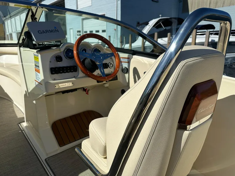 Slide: The Image of 2022 Chris-Craft Launch 23 boat interior with Garmin navigation and wooden steering wheel. - 11