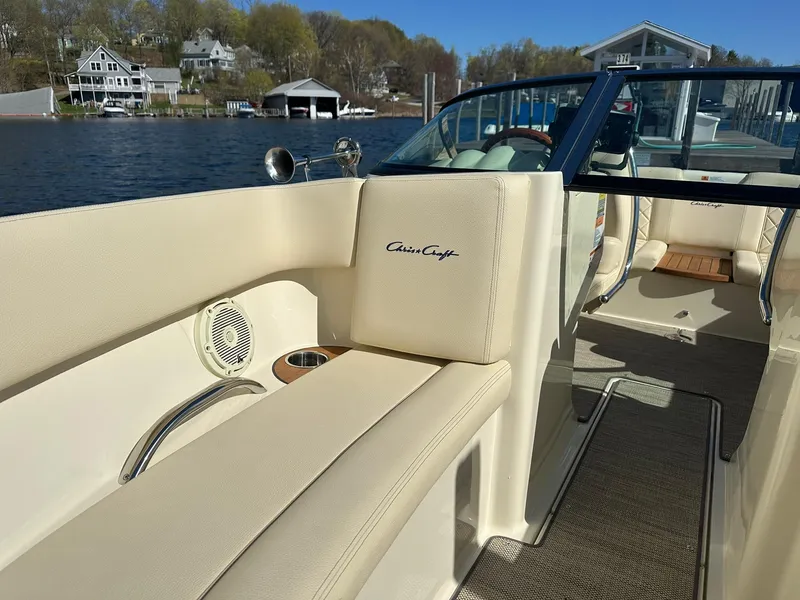 Slide: The Image of 2022 Chris-Craft Launch 23 boat interior with beige seating and lake view. - 16