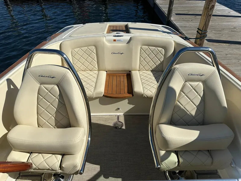 Slide: The Image of 2022 Chris-Craft Launch 23 boat interior with beige quilted seats and wooden accents. - 18