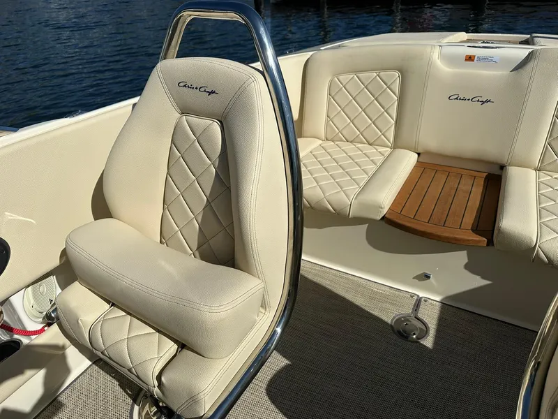 Slide: The Image of 2022 Chris-Craft Launch 23 boat interior with beige quilted seats and wooden accents. - 19