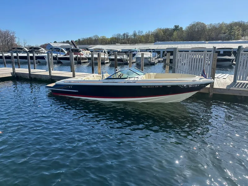 Slide: The Image of 2022 Chris-Craft Launch 23 boat docked at a marina on a sunny day. - 2