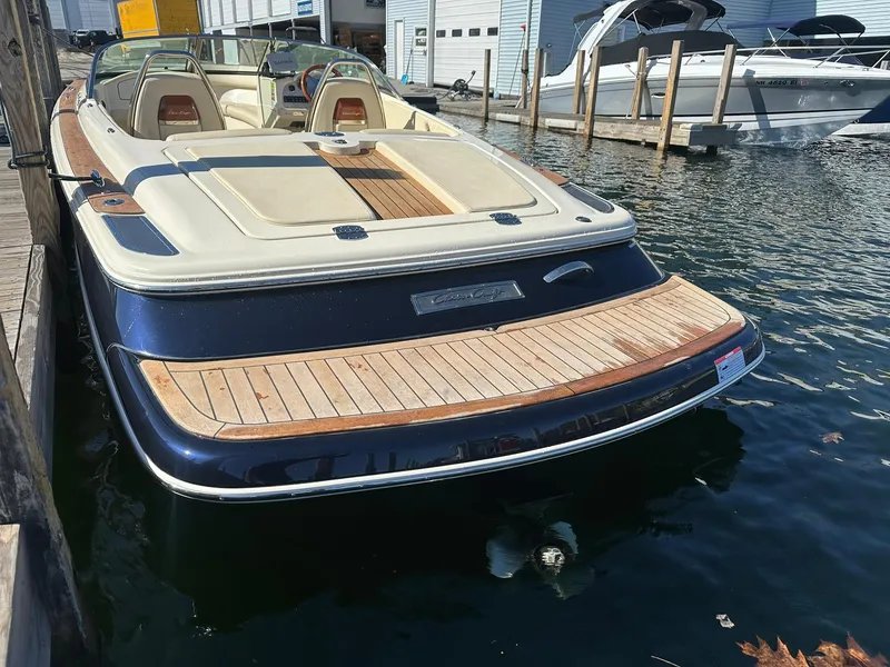 Slide: The Image of 2022 Chris-Craft Launch 23 boat docked, showcasing elegant design and spacious seating. - 6