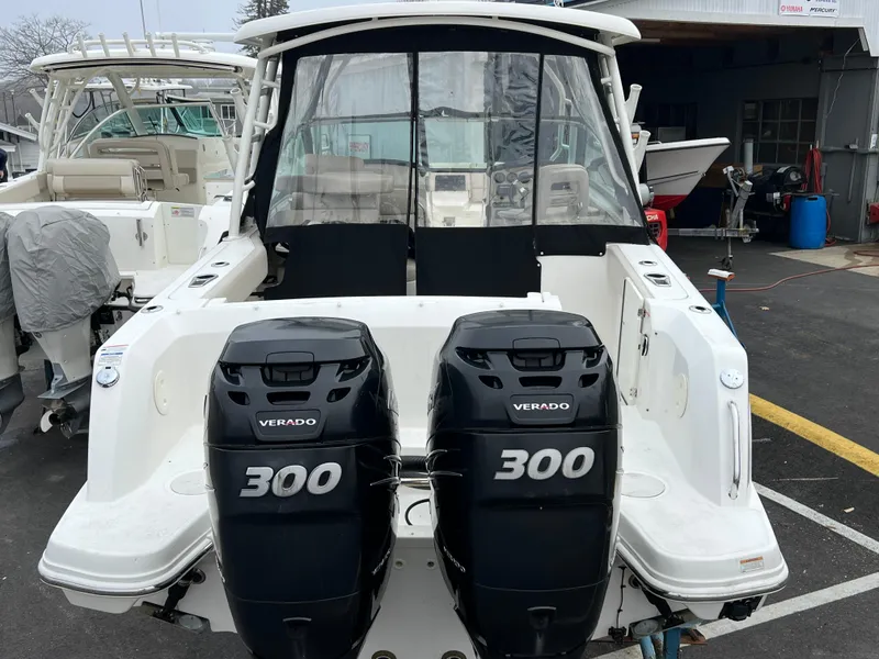 Slide: The Image of 2017 Boston Whaler 270 Vantage with twin 300 Verado engines, docked at a marina. - 2