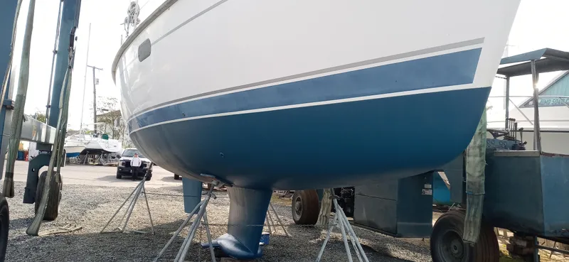 Slide: The Image of 2002 Hunter 380 sailboat on stands in a boatyard, showing blue hull and keel. - 29