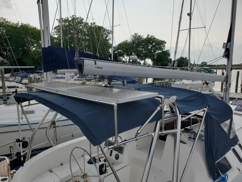 Slide: The Image of 2002 Hunter 380 sailboat docked, featuring a covered cockpit and solar panel. - 6