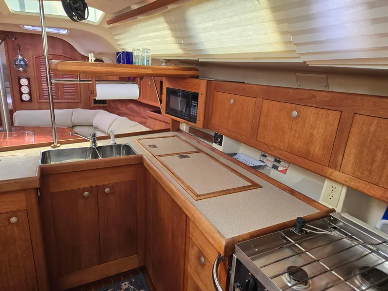 Slide: The Image of Interior of 2002 Hunter 380 sailboat kitchen with wood cabinetry and modern appliances. - 8