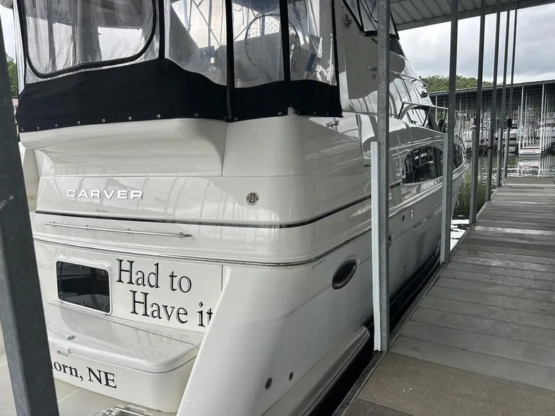 Slide: The Image of 2005 Carver 396 AFT yacht docked, featuring "Had to Have it" text on the stern. - 2