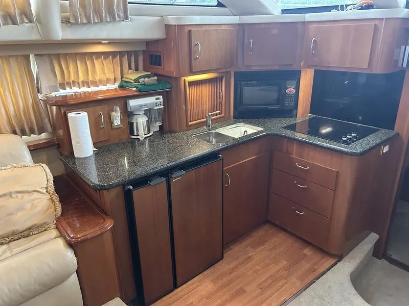 Slide: The Image of 2005 Carver 396 AFT yacht kitchen with wood cabinets, granite countertops, and modern appliances. - 30