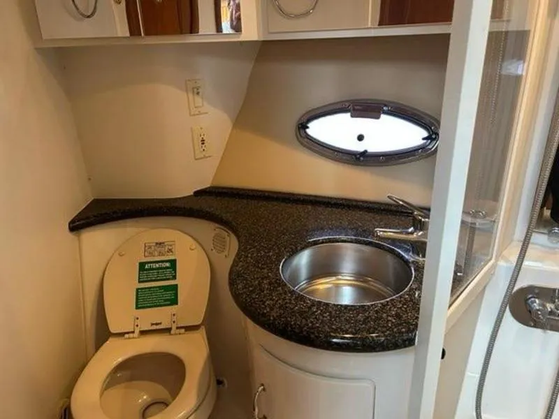 Slide: The Image of 2005 Carver 396 AFT yacht bathroom with sink, toilet, and porthole window. - 23
