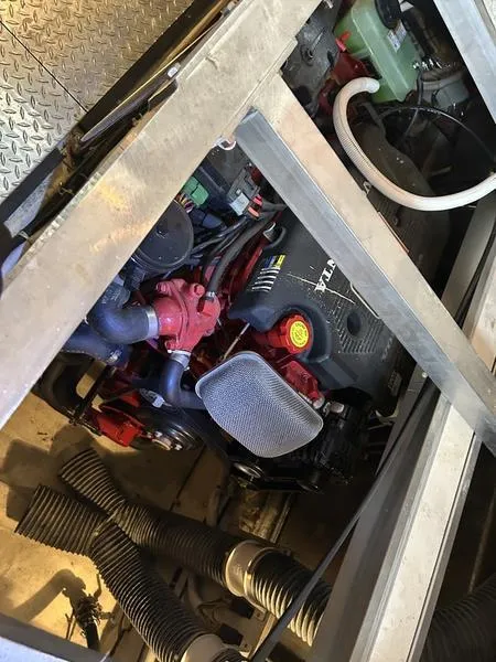 Slide: The Image of Engine compartment of a 2005 Carver 396 AFT boat, showcasing mechanical components and hoses. - 31