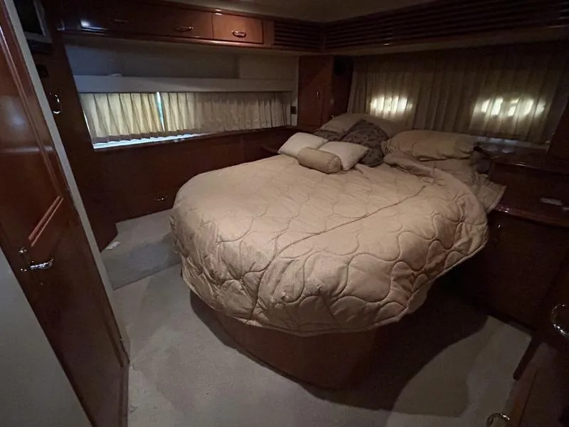 Slide: The Image of Cozy bedroom interior of 2005 Carver 396 AFT yacht with beige bedding and wood accents. - 24