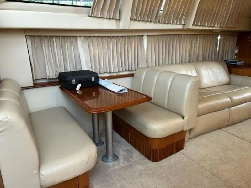 Slide: The Image of Interior of a 2005 Carver 396 AFT yacht with beige seating and wooden table. - 28