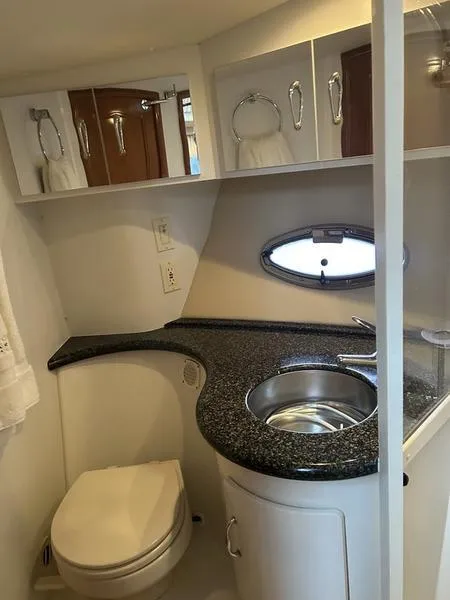 Slide: The Image of 2005 Carver 396 AFT yacht bathroom with sink, toilet, and storage cabinets. - 29