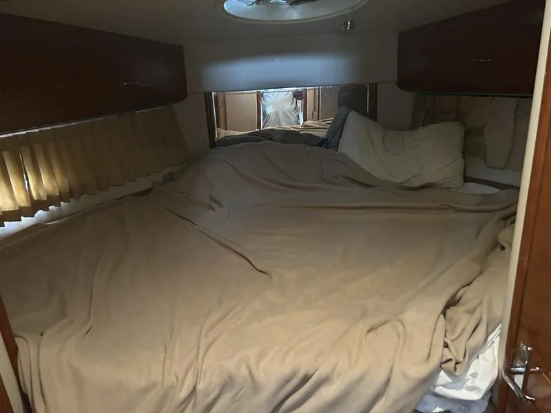 Slide: The Image of Cozy bedroom interior of 2005 Carver 396 AFT yacht with beige bedding and wooden cabinets. - 37