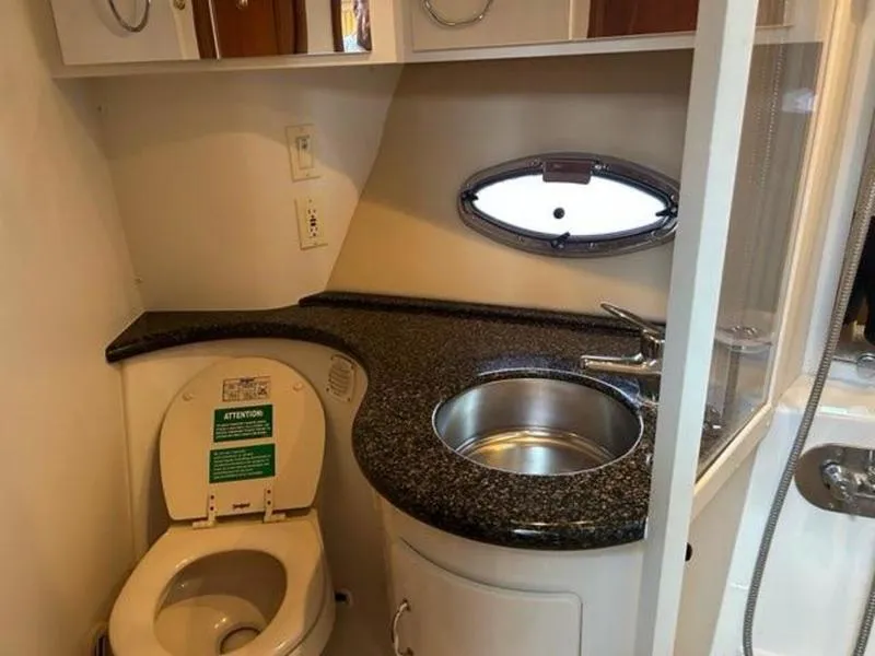Slide: The Image of 2005 Carver 396 AFT yacht bathroom with toilet, sink, and porthole window. - 48