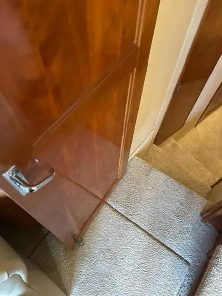 Slide: The Image of Interior view of 2005 Carver 396 AFT yacht, featuring wooden door and carpeted stairs. - 49