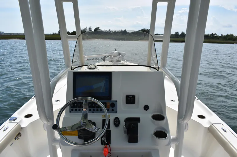 Slide: The Image of 2021 Key West 230 BR boat dashboard with steering wheel and navigation system on water. - 11