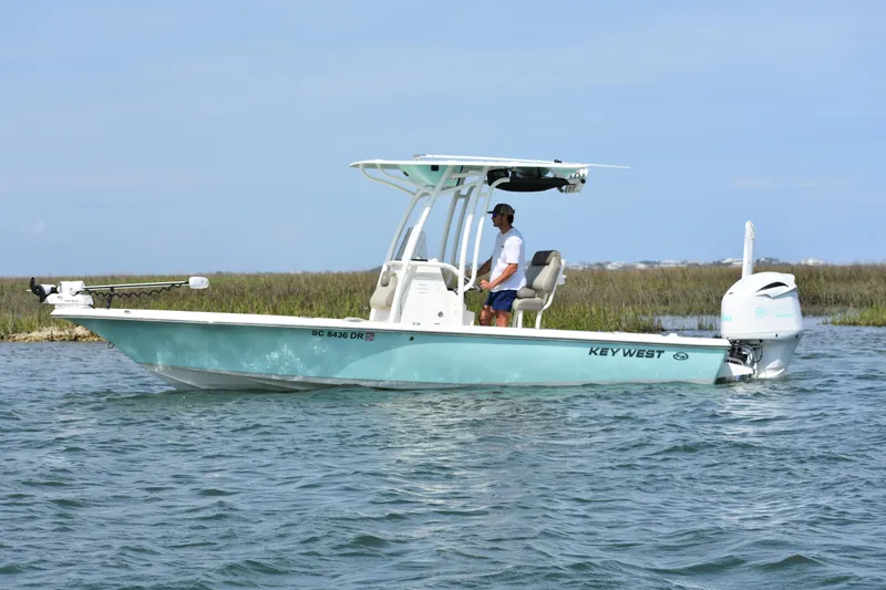 Slide: The Image of 2021 Key West 230 BR boat on water with driver, clear sky background. - 3