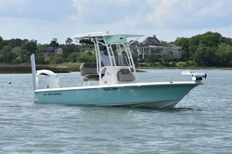 The Image of 2021 Key West 230 BR boat on calm water, with scenic background. - 1