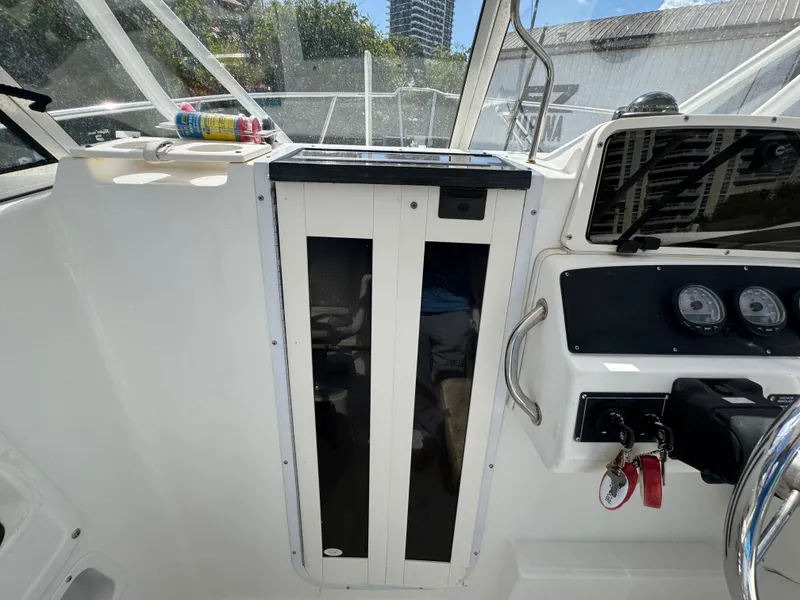 Slide: The Image of 1999 Boston Whaler Conquest 23 cockpit with gauges and storage compartment. - 11