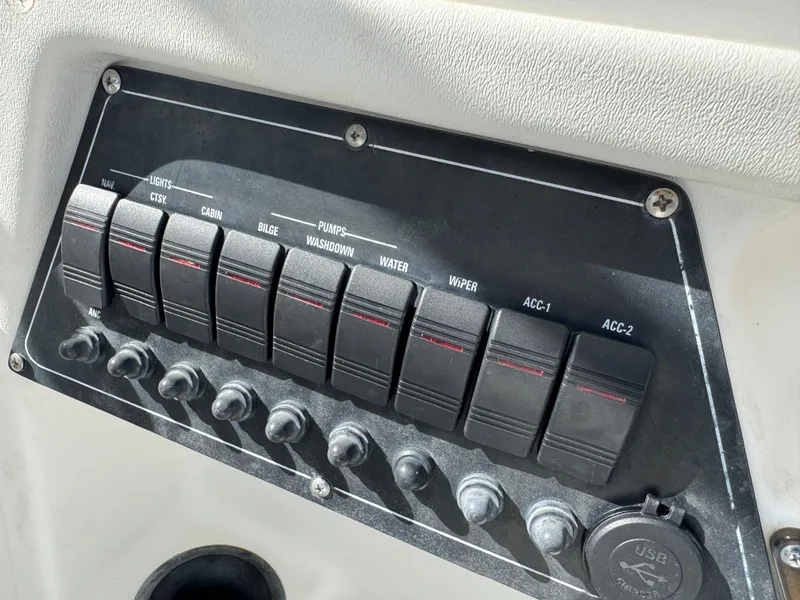 Slide: The Image of Control panel of a 1999 Boston Whaler Conquest 23 boat with labeled switches. - 21