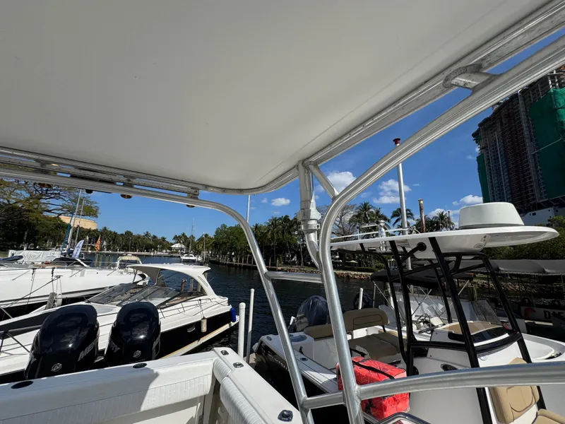 Slide: The Image of 1999 Boston Whaler Conquest 23 docked, surrounded by other boats, under a clear blue sky. - 23