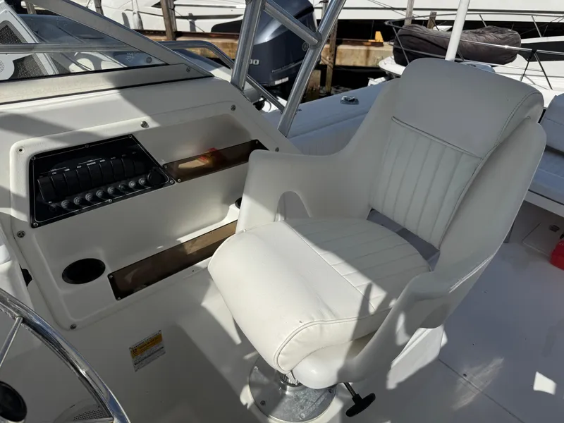 Slide: The Image of Captain's chair and control panel on a 1999 Boston Whaler Conquest 23 boat. - 25