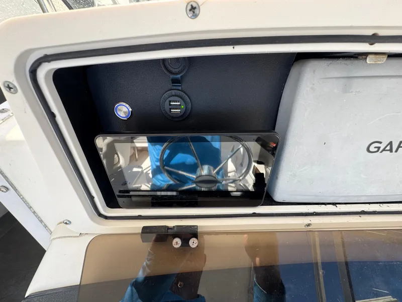 Slide: The Image of 1999 Boston Whaler Conquest 23 dashboard with Garmin device and USB ports. - 26