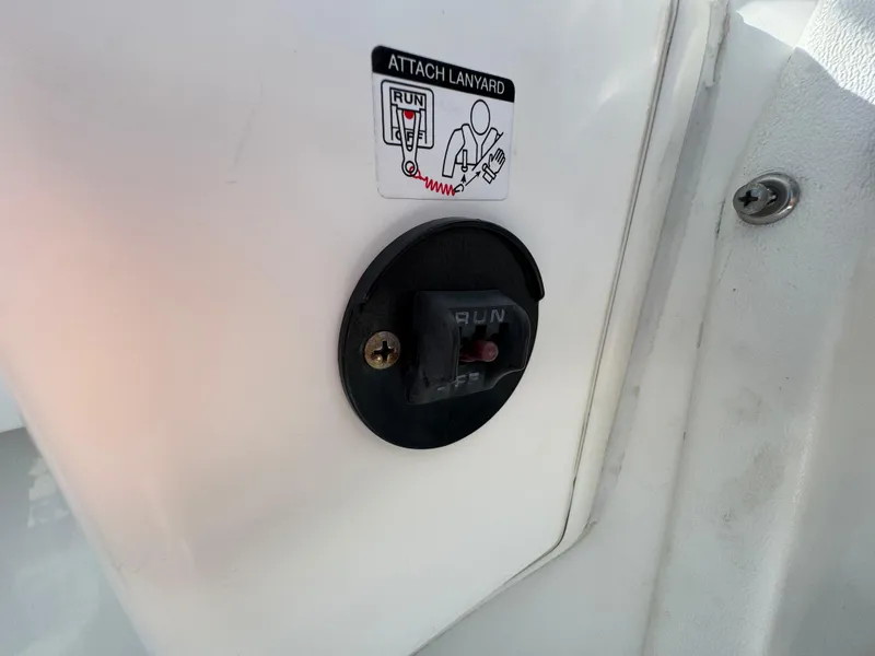 Slide: The Image of 1999 Boston Whaler Conquest 23 lanyard attachment point with "RUN" switch. - 27