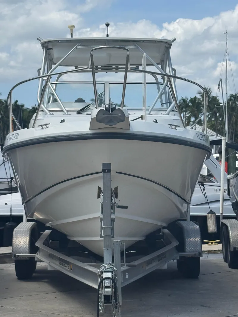 Slide: The Image of 1999 Boston Whaler Conquest 23 boat on trailer, parked outdoors. - 3