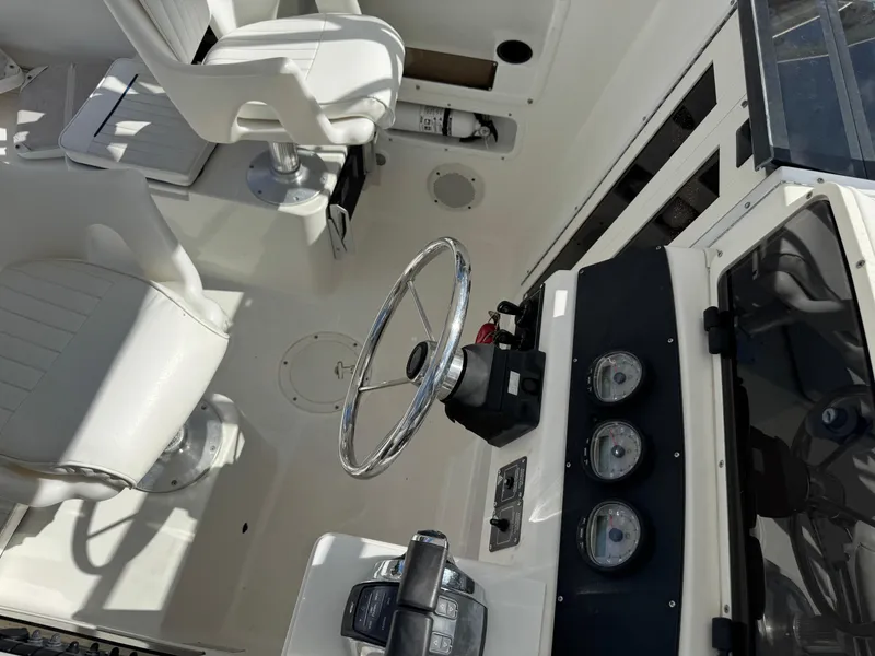 Slide: The Image of 1999 Boston Whaler Conquest 23 cockpit with steering wheel and gauges. - 30