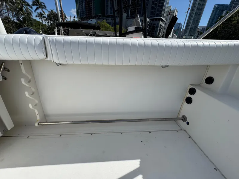 Slide: The Image of 1999 Boston Whaler Conquest 23 interior with white seating and rod holders. - 34