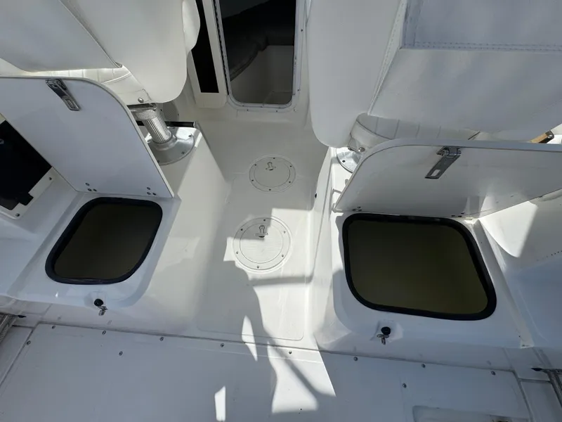 Slide: The Image of 1999 Boston Whaler Conquest 23 interior with open storage compartments and seating. - 42