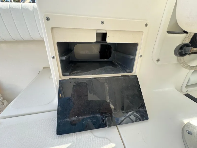 Slide: The Image of 1999 Boston Whaler Conquest 23 storage compartment with open lid, showcasing interior space. - 43