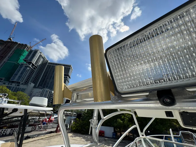 Slide: The Image of Boston Whaler Conquest 23 boat detail with rod holders and light, cityscape background. - 46