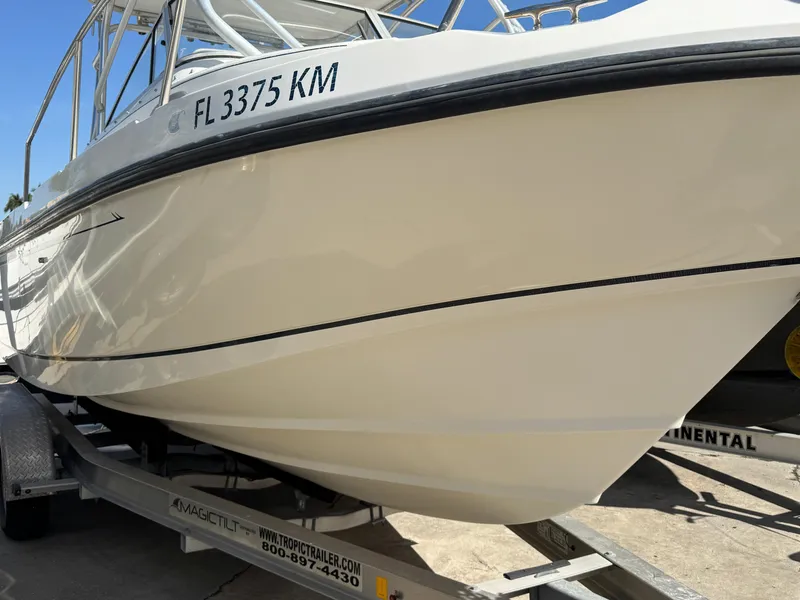 Slide: The Image of 1999 Boston Whaler Conquest 23 boat on trailer, side view, with registration number visible. - 5