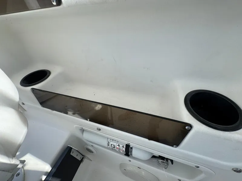 Slide: The Image of Interior of a 1999 Boston Whaler Conquest 23 boat, featuring cup holders and storage. - 51