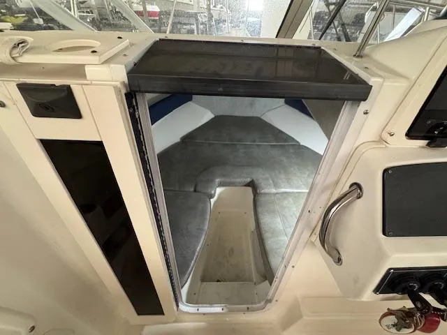 Slide: The Image of 1999 Boston Whaler Conquest 23 cabin interior with seating and storage. - 7