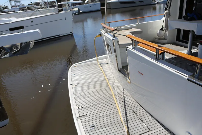 Slide: The Image of Beneteau Swift Trawler 44, 2020 model, docked with wooden railings and spacious deck. - 26