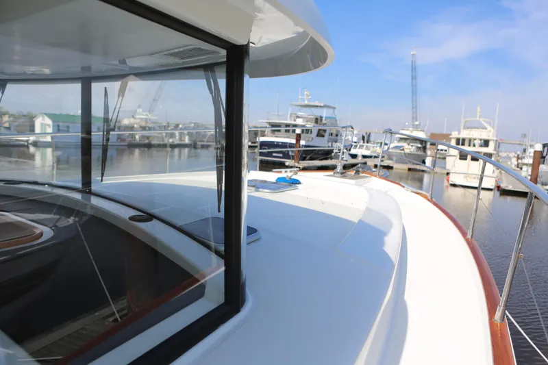 Slide: The Image of 2020 Beneteau Swift Trawler 44 docked at marina, showcasing sleek design and spacious deck. - 39