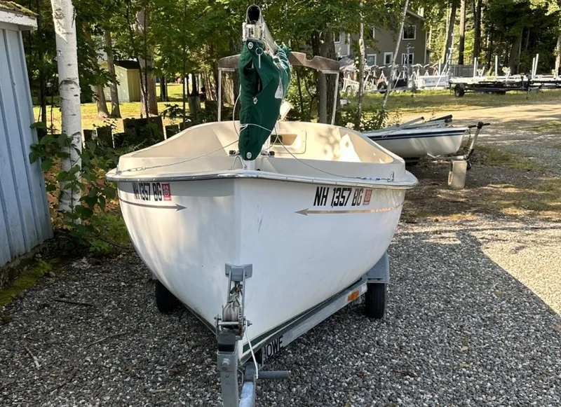Slide: The Image of 2001 Com-Pac Picnic Cat sailboat on trailer, parked outdoors on gravel. - 4