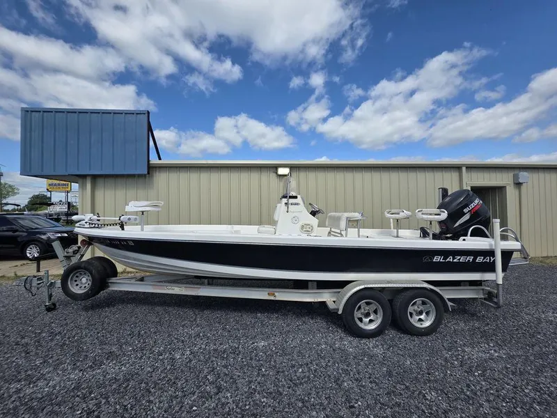 Slide: The Image of 2008 Blazer Bay 2420 Professional boat on trailer, parked outdoors under cloudy sky. - 1