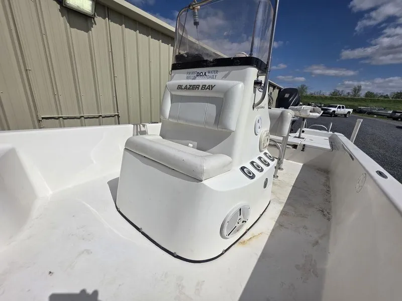 Slide: The Image of 2008 Blazer Bay 2420 Professional boat with console and seating, outdoors under blue sky. - 14