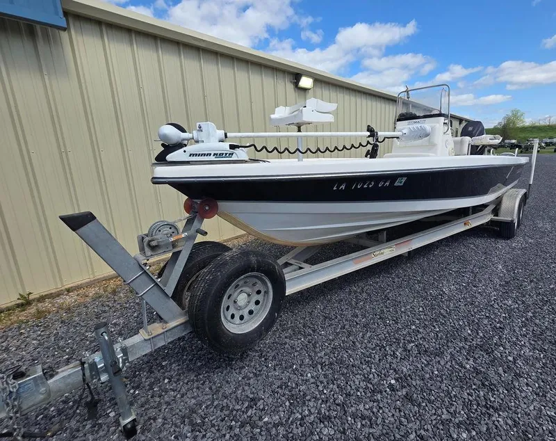 Slide: The Image of 2008 Blazer Bay 2420 Professional boat on trailer, parked on gravel near a building. - 3