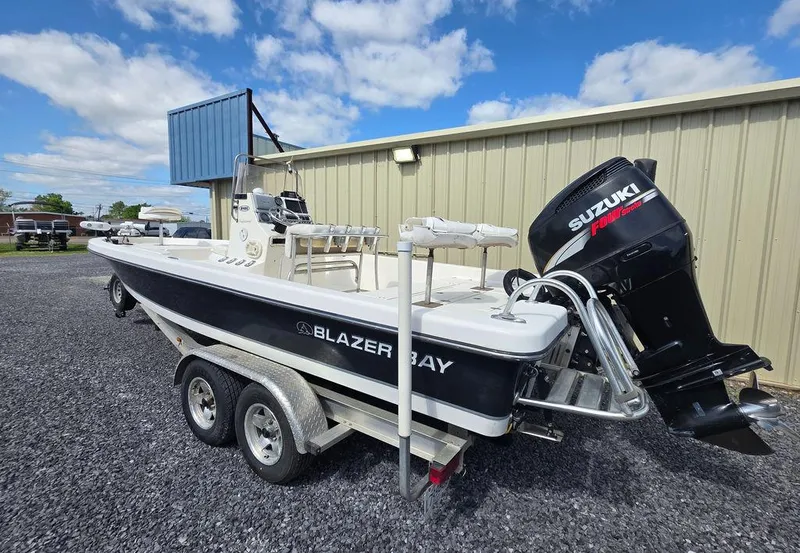 Slide: The Image of 2008 Blazer Bay 2420 Professional boat with Suzuki engine on trailer, parked outdoors. - 4
