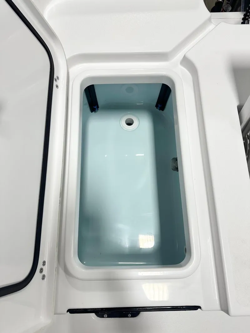 Slide: The Image of 2025 Sportsman Masters 247OE Bay Boat livewell, open lid, white interior. - 13